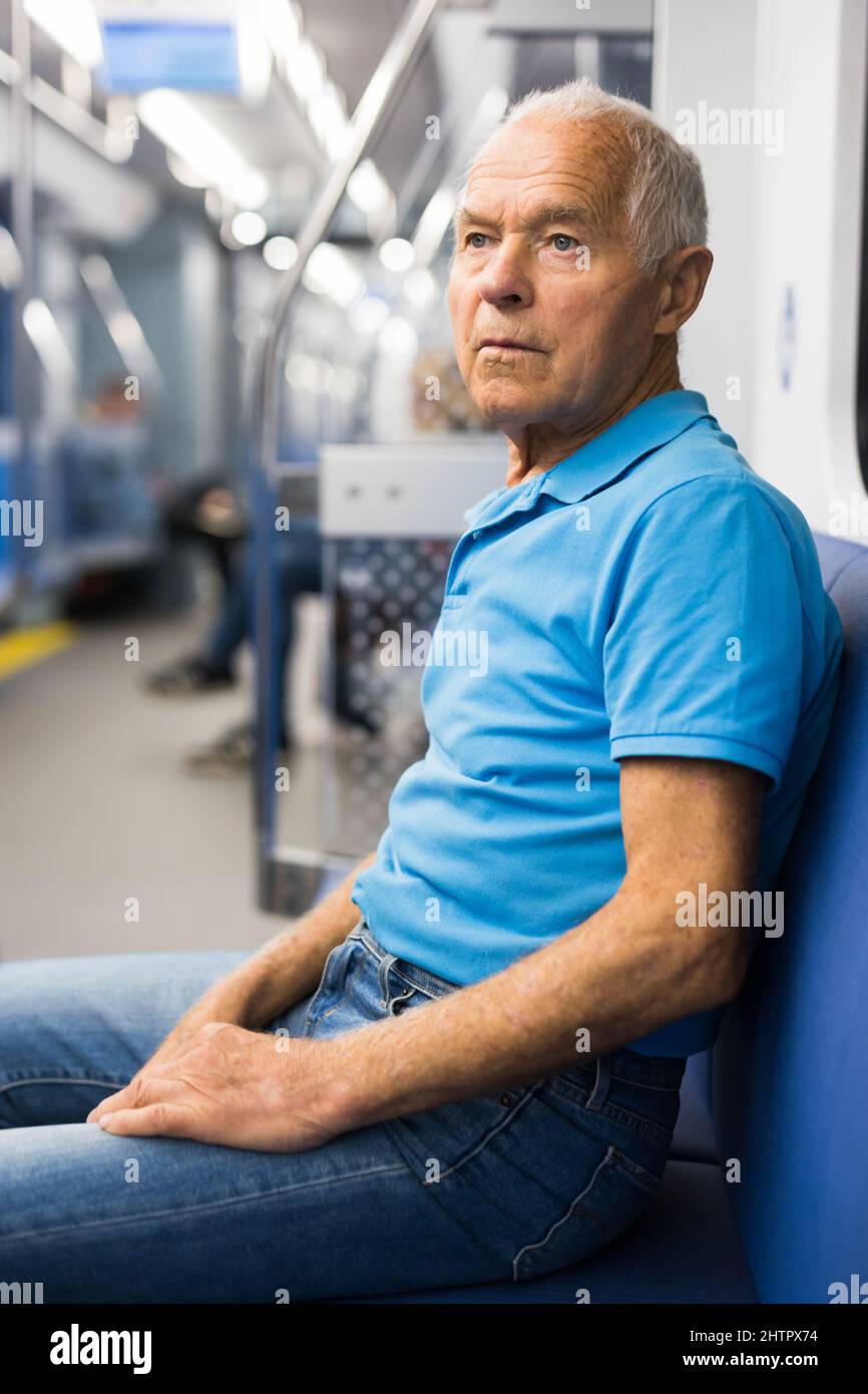 Old man sitting in subway car Stock Photo