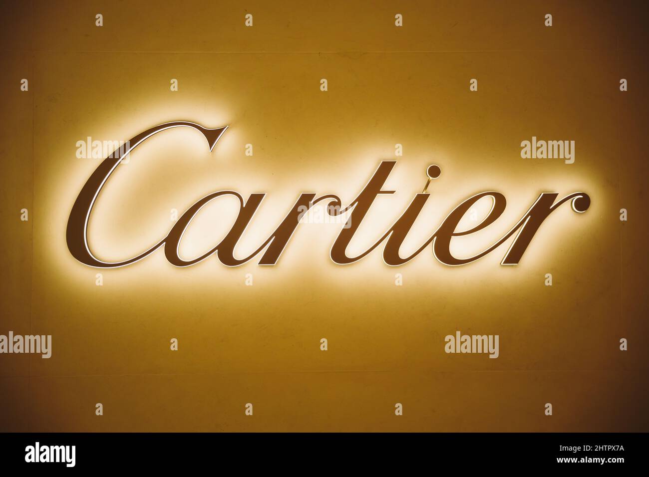 Dubai, UAE, United Arab Emirates - May 28, 2021: Close golden logotype Cartier (jeweler) Brand at wall of store in shopping center. Cartier Stock Photo