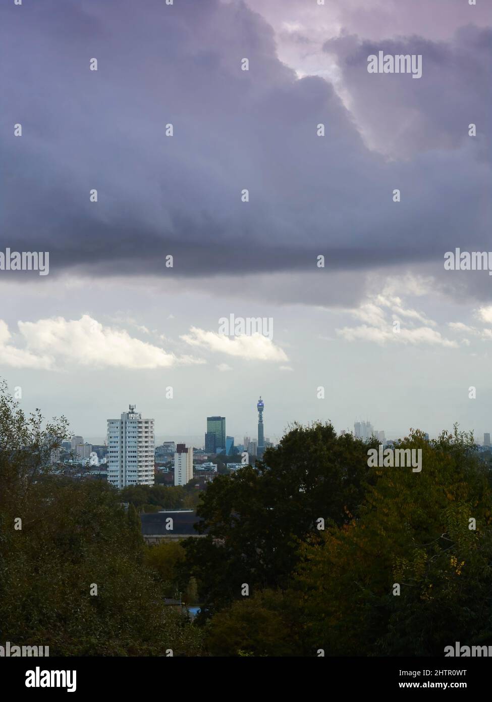 A London skyline from Parliament Hill Fields, with the buildings pressed under a leaden sky just holding back the sun’s attempts to break through. Stock Photo