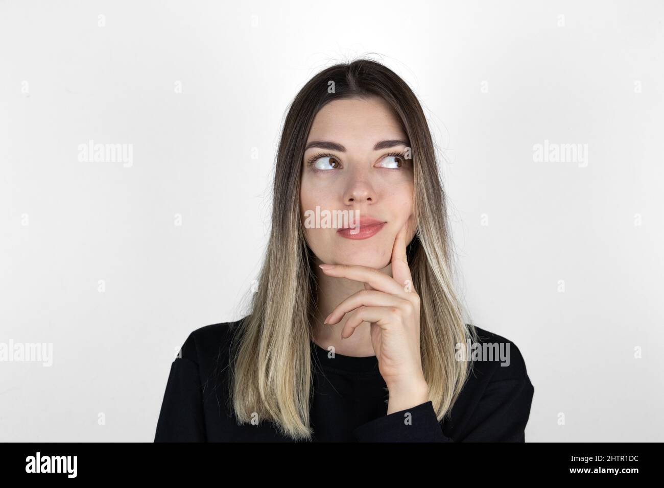 Young beautiful girl wearing casual clothes over isolated white background with hand on chin thinking about question, pensive expression. Stock Photo