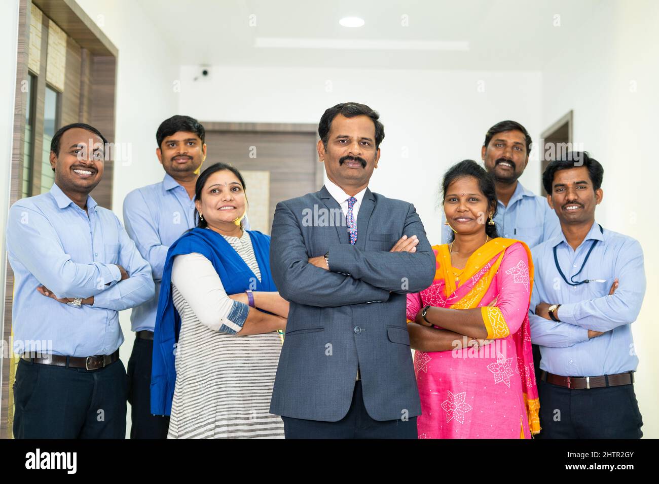 Diverse Indian corporate employees with arms crossed standing looking