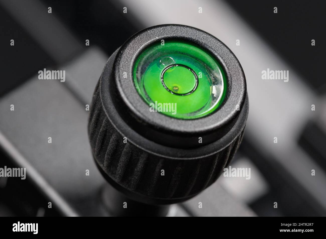 The bubble level of a photographic tripod is filled with green liquid. Macro  photography Stock Photo - Alamy