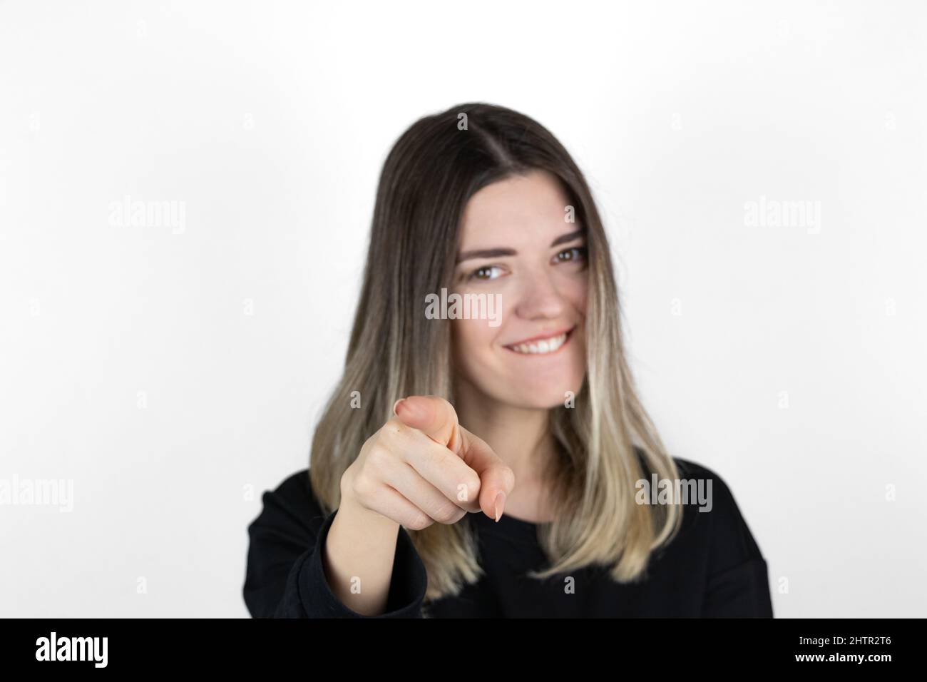 Positive cheerful young woman smiling pointing at camera with index fingers. Facial emotion. Success in life or studies. Stock Photo