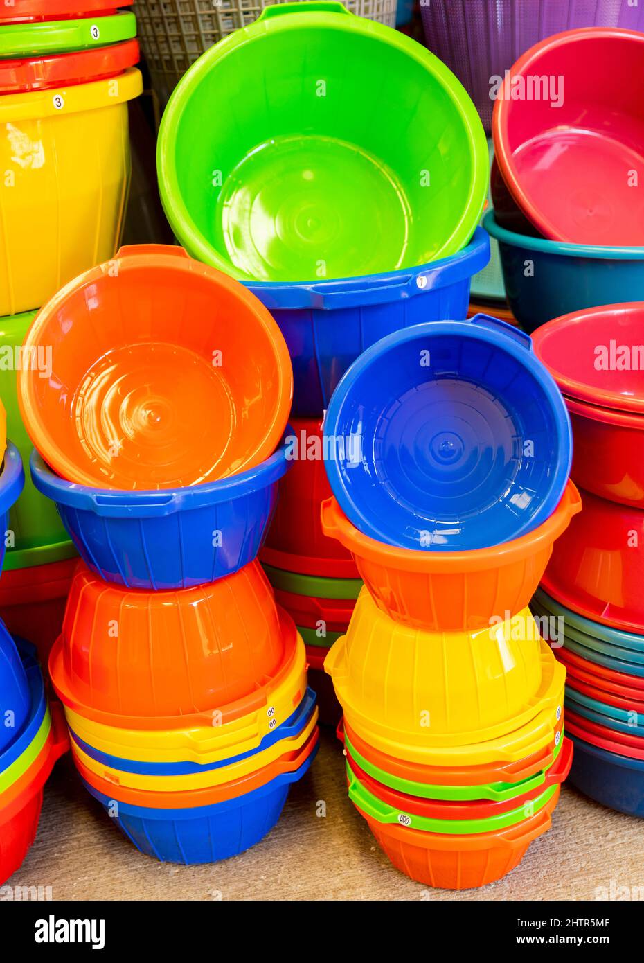 A collection of colourful plastic baskets for sale in a market place Stock Photo