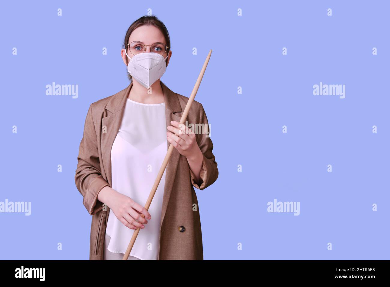 Woman teacher in medical face mask n95 on studio purple background ...