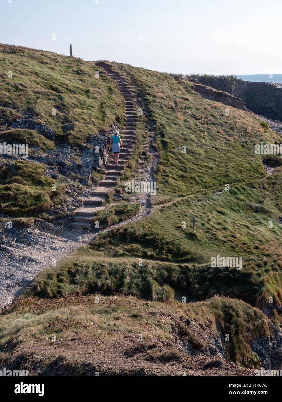 A woman walking on the West Coast path up steps at Porthcothan Bay Cornwall UK Stock Photo