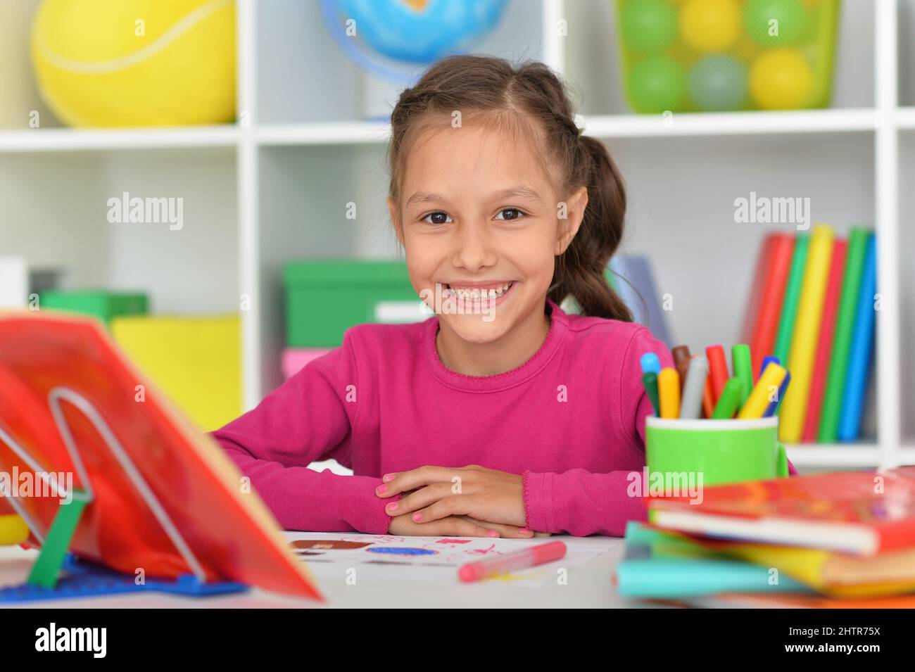 Porait of cute little girl studying at home Stock Photo - Alamy