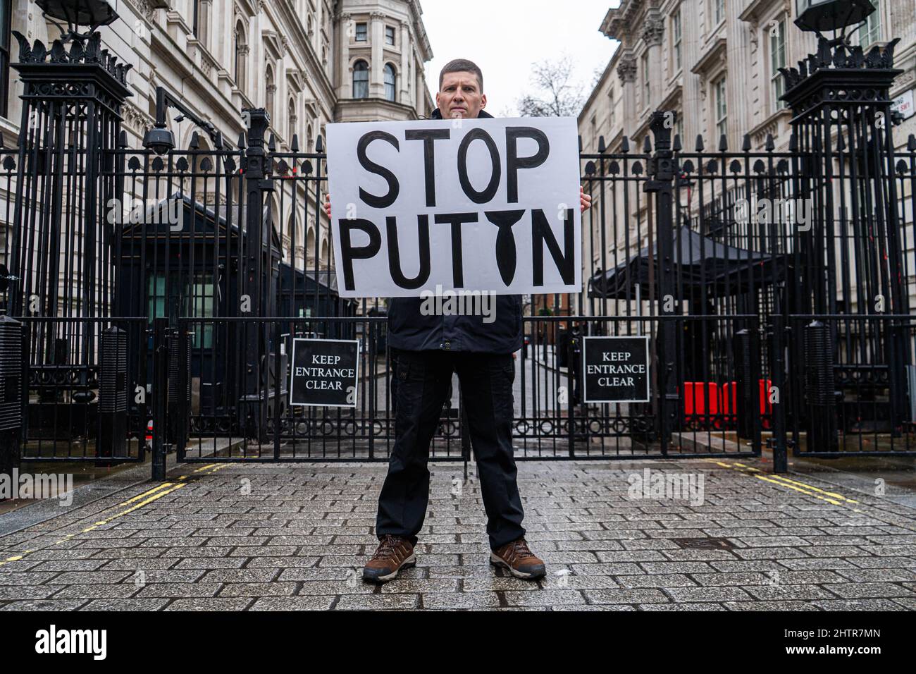 WESTMINSTER LONDON, UK. 2  March, 2022.  A protester stands  outside Downing Street with a sign 'Stop Putin' against the military invasion of Ukraine invasion  by Russia now in it's seventh day which has drawn  condemnation and protests  across cities in the world and triggered sanctions targeting Russian economic interests. Credit: amer ghazzal/Alamy Live News Stock Photo