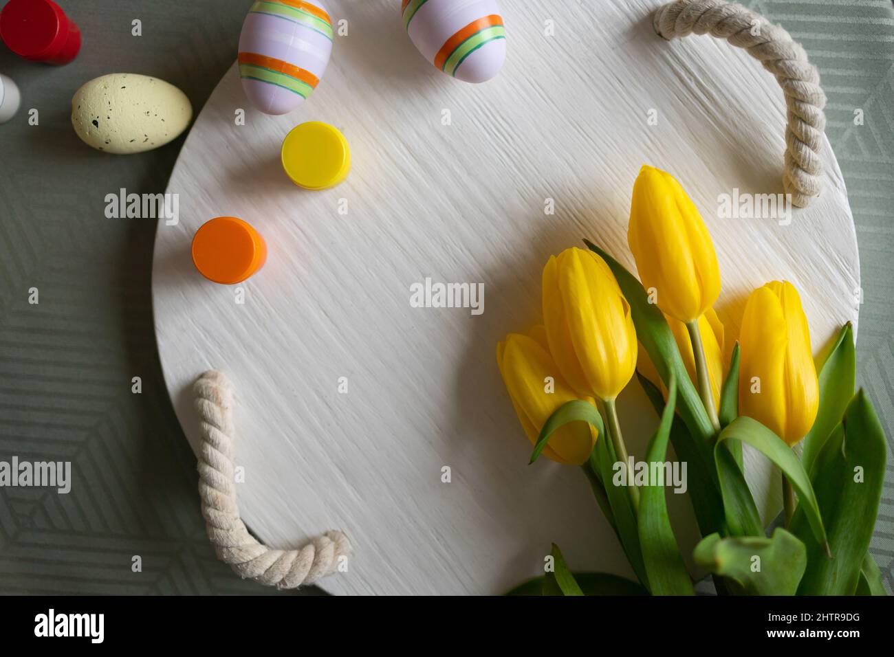 Easter eggs and yellow tulips on the table Stock Photo