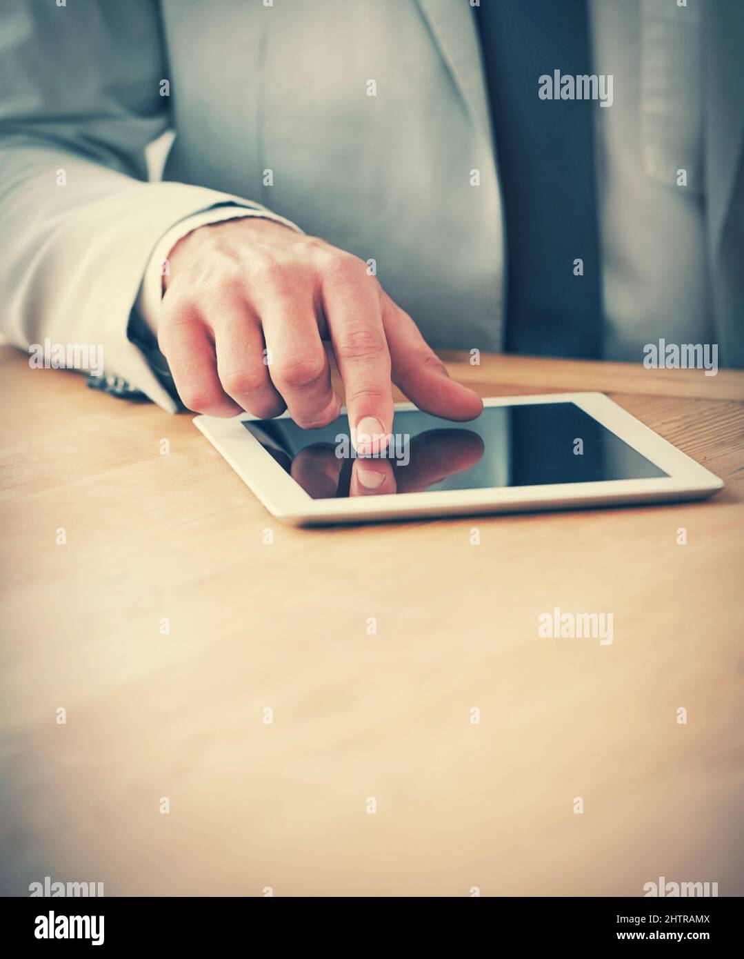 Taking notes on his digital tablet. Cropped shot of a businessman using