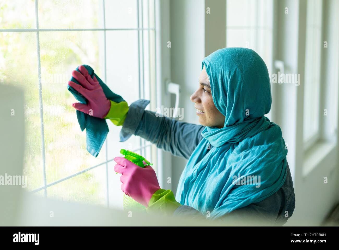Happy Muslim Woman Cleaning Modern House Living Room. High quality