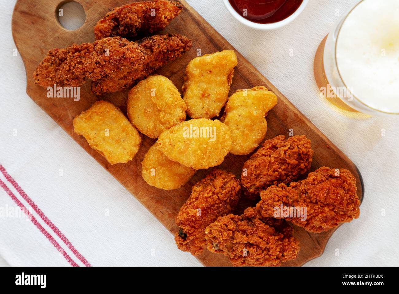 Tasty Fastfood Chicken Nuggets, Wings and Tenders with Sauce and Beer, top view. Overhead, from