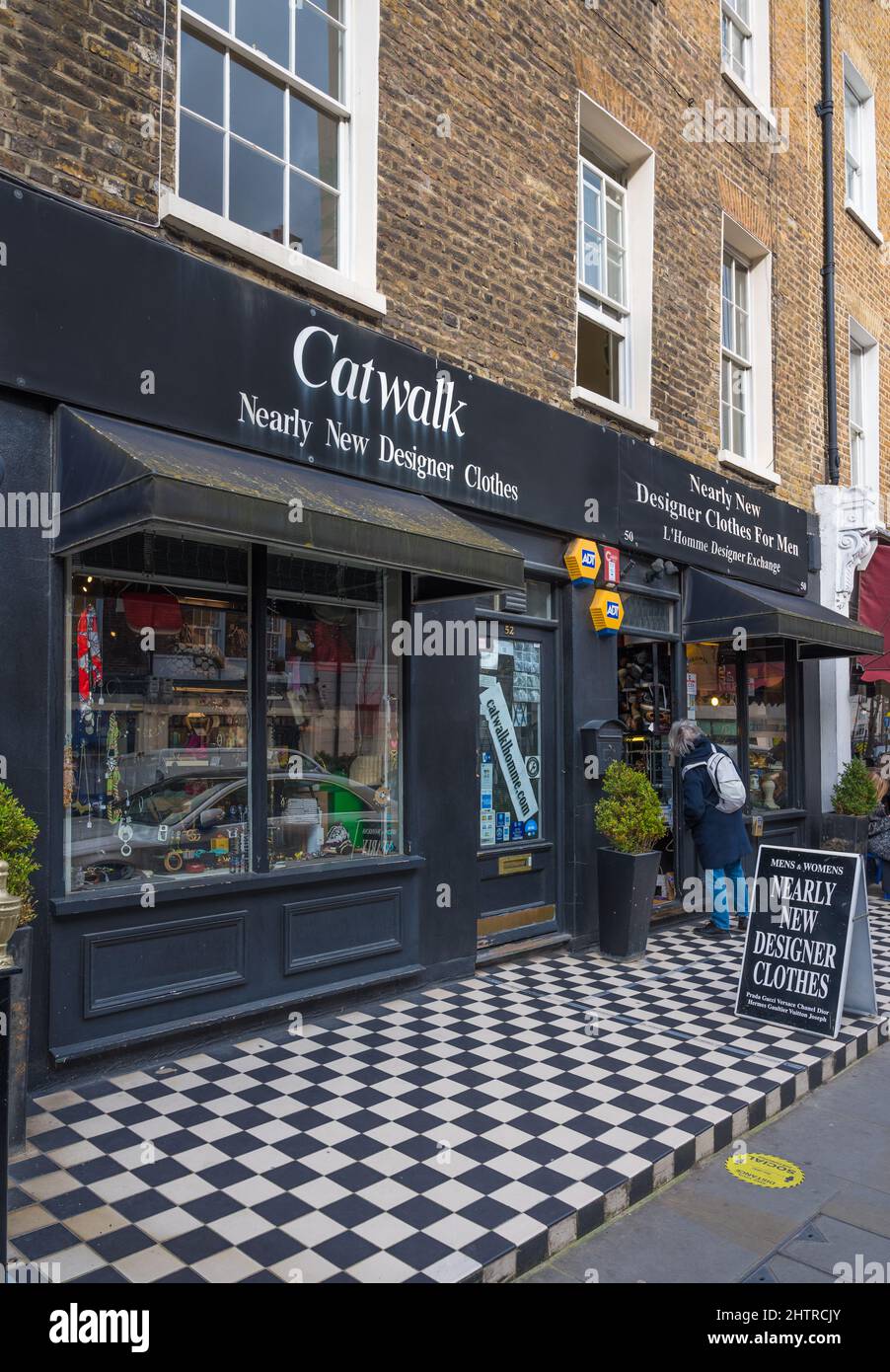 Exterior of Catwalk Nearly New Designer Clothes shop. Lone woman looking in window. Blandford