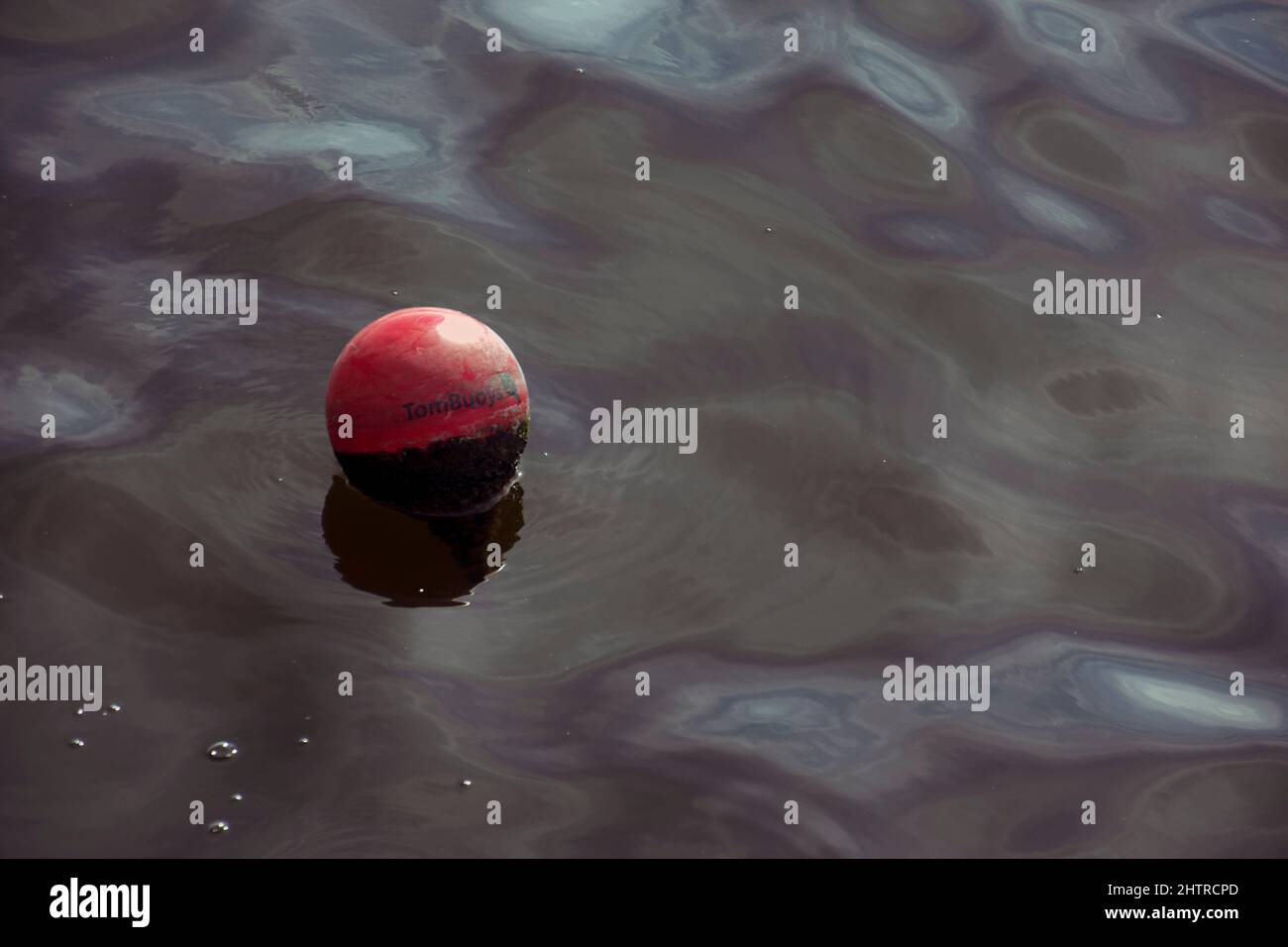 London, UK - September 17th 2021: a round red buoy drifting on the water Stock Photo