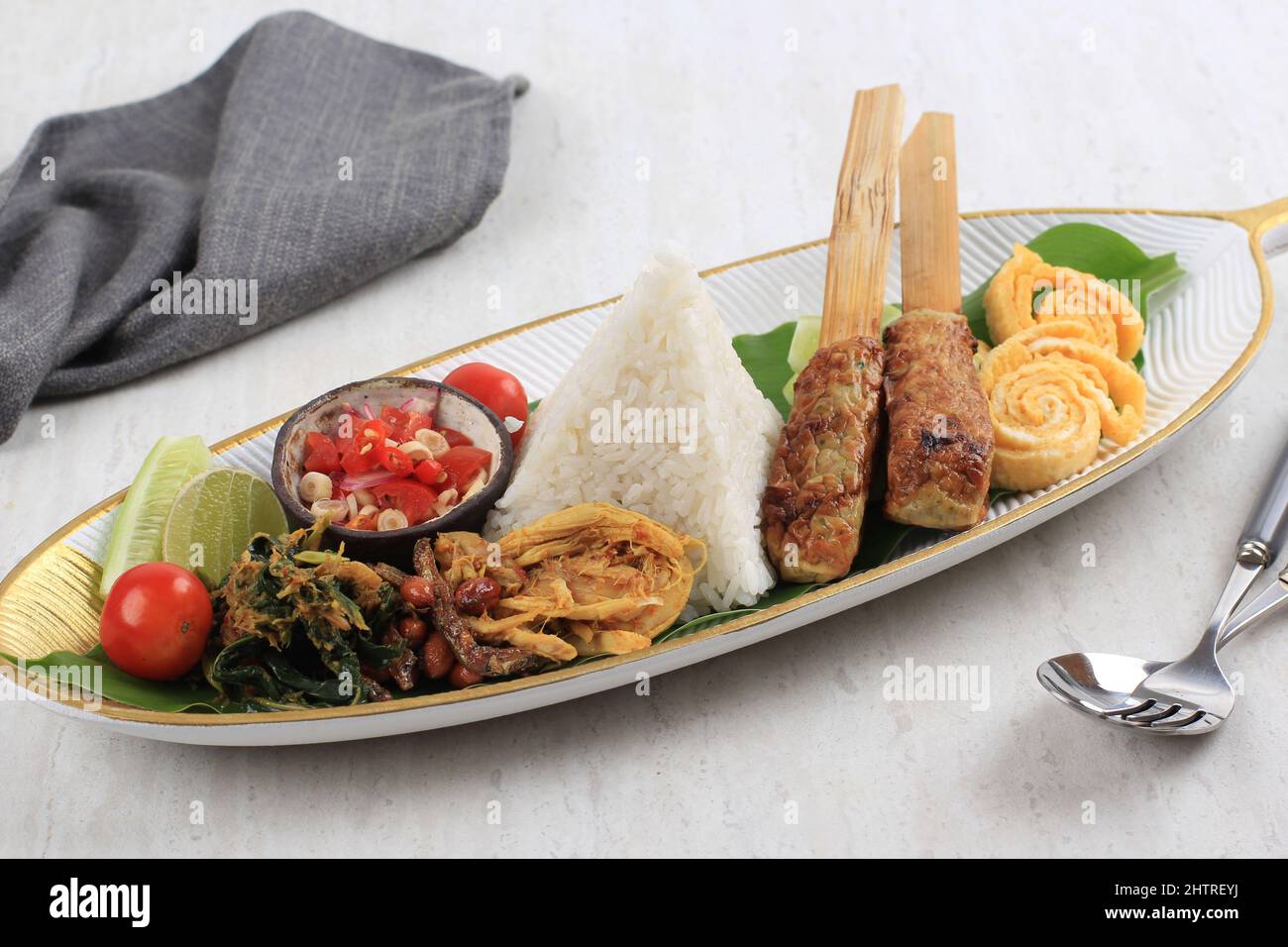 Nasi Campur Bali. Balinese Dish of Steamed Rice with Variety of Side Dishes, such as Sate Lilit, Ayam Pelalah, Telur Dadar, Kacang Teri, Jukut Urap. Stock Photo