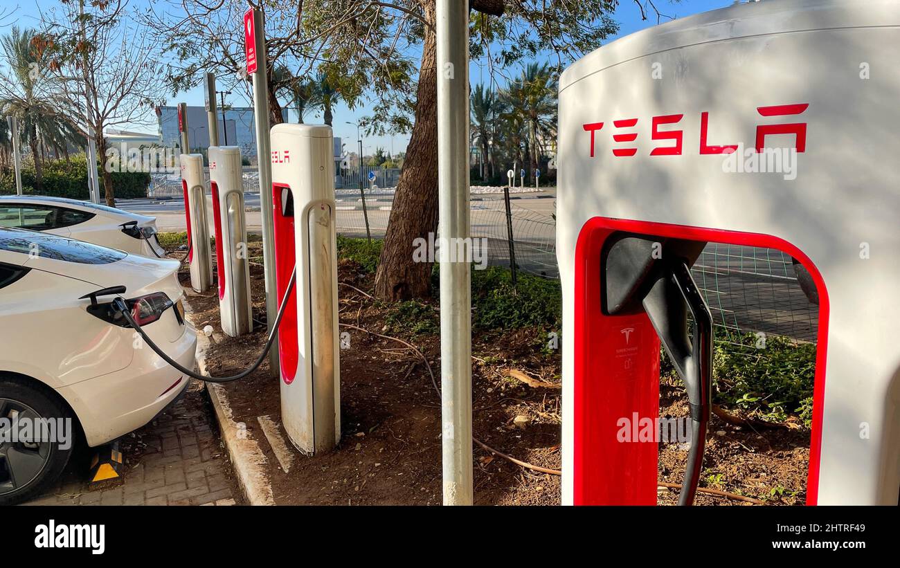 Haifa, Israel - February 6, 2022: Tesla cars while charging at Tesla supercharger Station. Tesla Charging point. Stock Photo