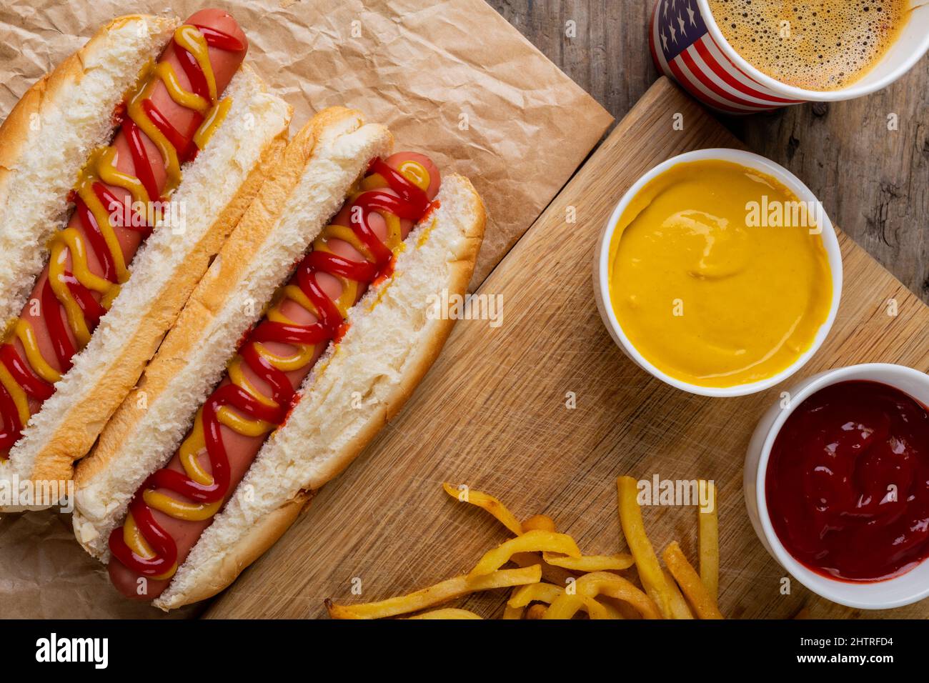 Hot dogs with mustered and tomato sauce served with drink and french