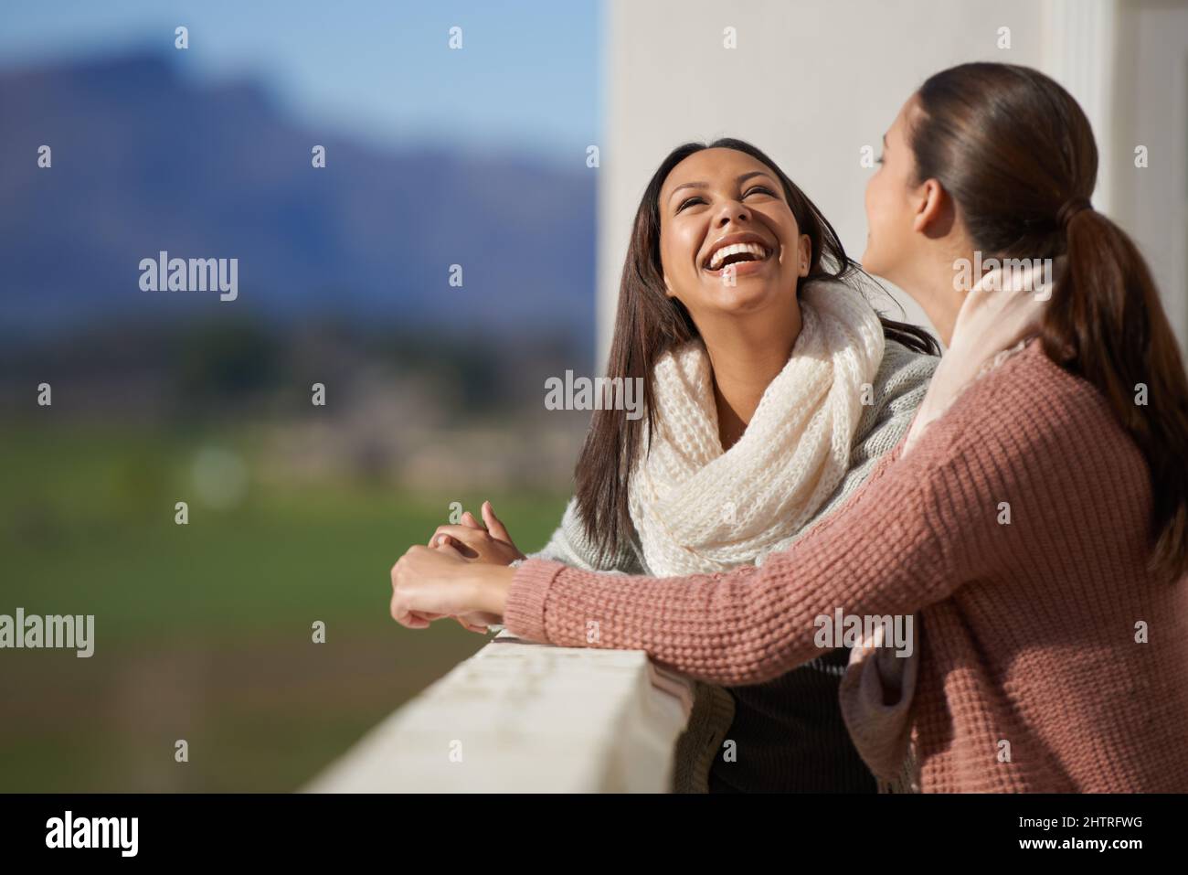 Friendship uplifts the soul. Two lovely woman having a conversation on a balcony. Stock Photo