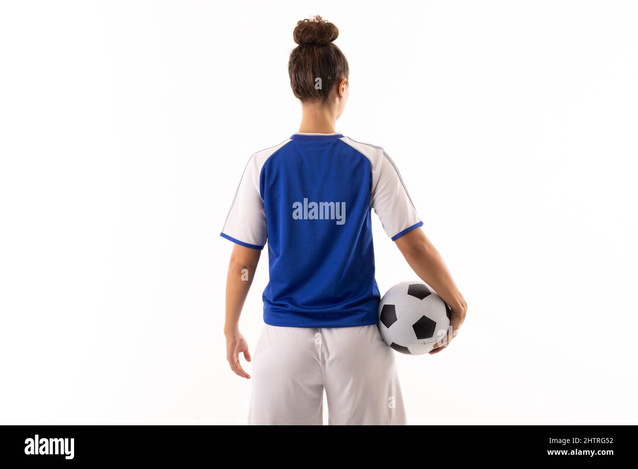 Rear view of biracial young female soccer player with soccer ball