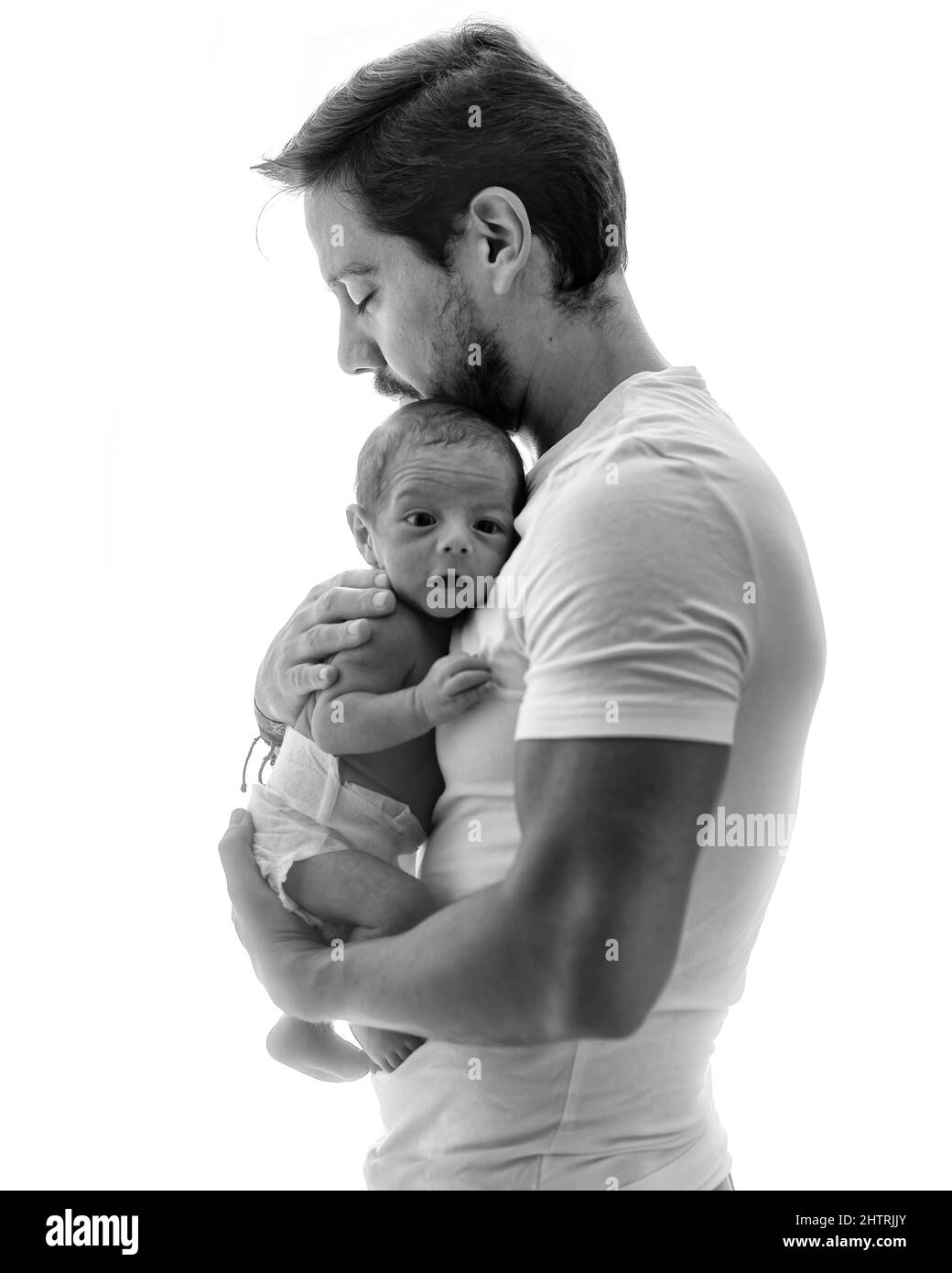 Father with his new born in a back-lit scene in black & white Stock Photo