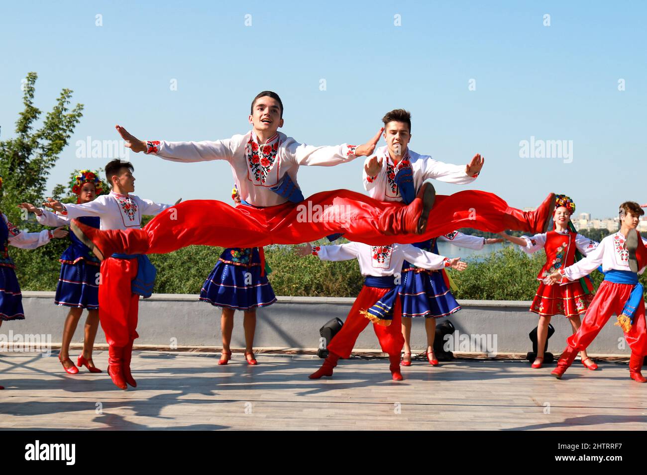 Young people in national Ukrainian costumes dance on Independence Day, Ukraine. Guys in national costumes, embroidered shirts jump high in dance. Patr Stock Photo