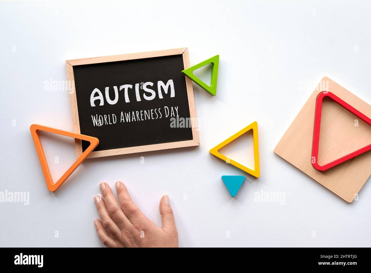 Text Autism awareness month on blackboard. Nested wood triangles in