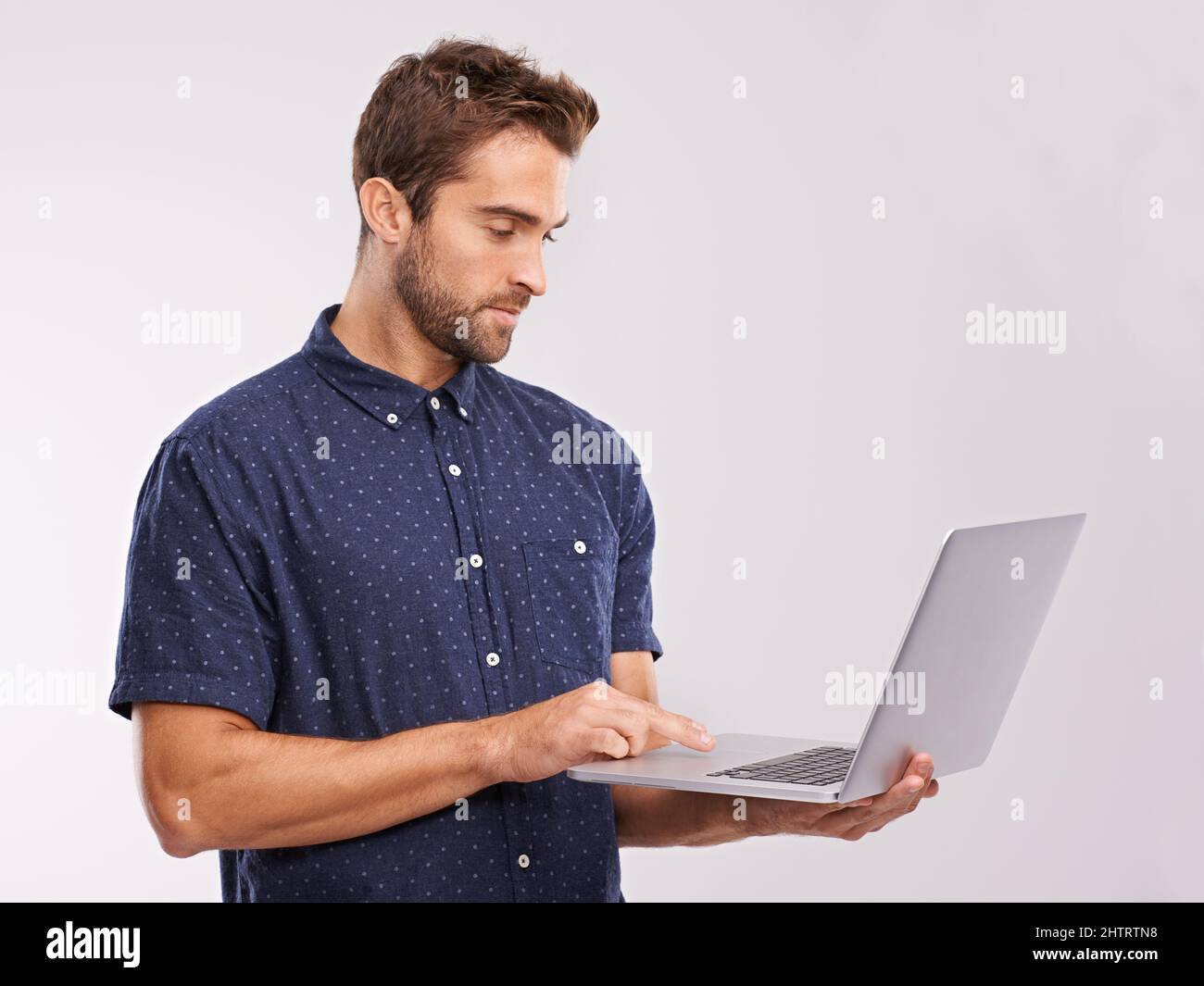 Online freedom. A studio shot of a handsome man using a laptop. Stock Photo