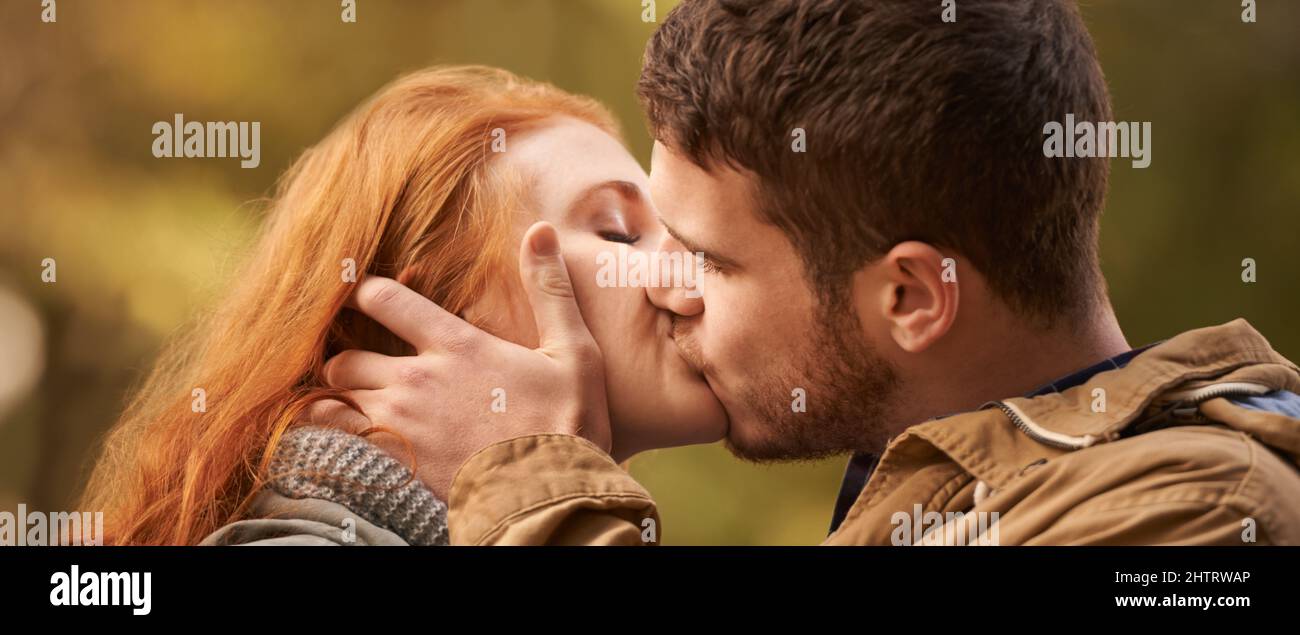 Kiss me like you miss me. Shot of a happy young couple sharing a kiss outdoors. Stock Photo