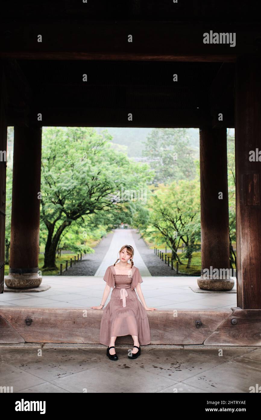 Cute Japanese Girl Sitting In Between Nanzenji Temples Wooden Poles In