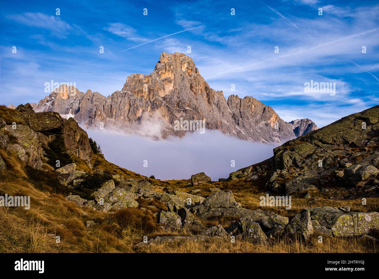Summit and west face of Cimon della Pale, one of the main summits of the Pala group, standing out from the clouds, from above Rolle Pass in autumn. Stock Photo