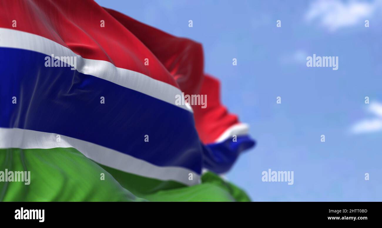 Detail of the national flag of Gambia waving in the wind on a clear day. Gambiac iis a country in West Africa. Selective focus. Seamless slow motion Stock Photo
