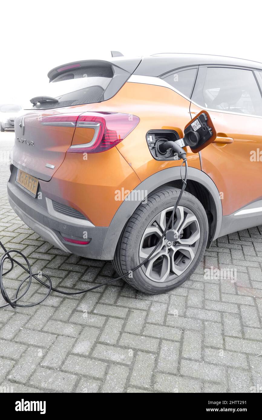 Electric car is charging its batteries at a charging station Stock