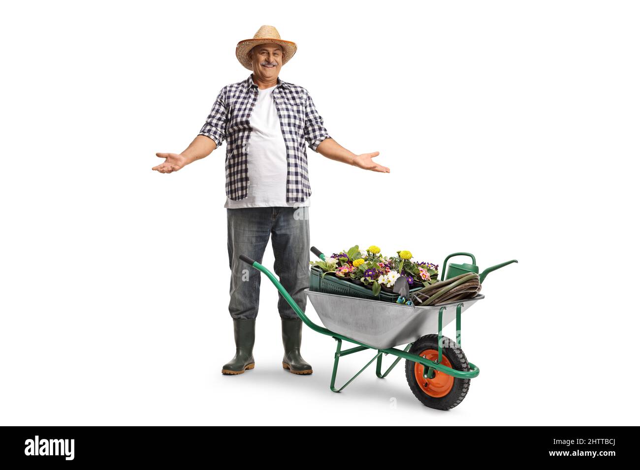 Full length portrait of a smiling mature farmer with a straw hat with a hand cart full of plants isolated on white background Stock Photo