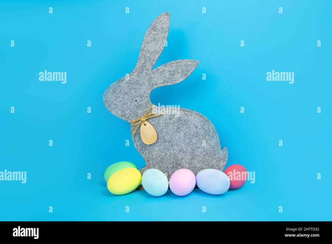 Easter, soft, gray hare and eggs are plain, multi-colored on a blue background.  Stock Photo
