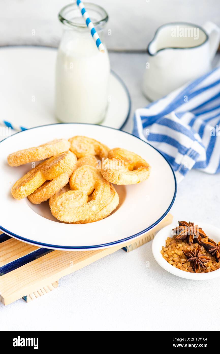 Traditional Puff pastry spiral biscuits known as a pig's ears on plate