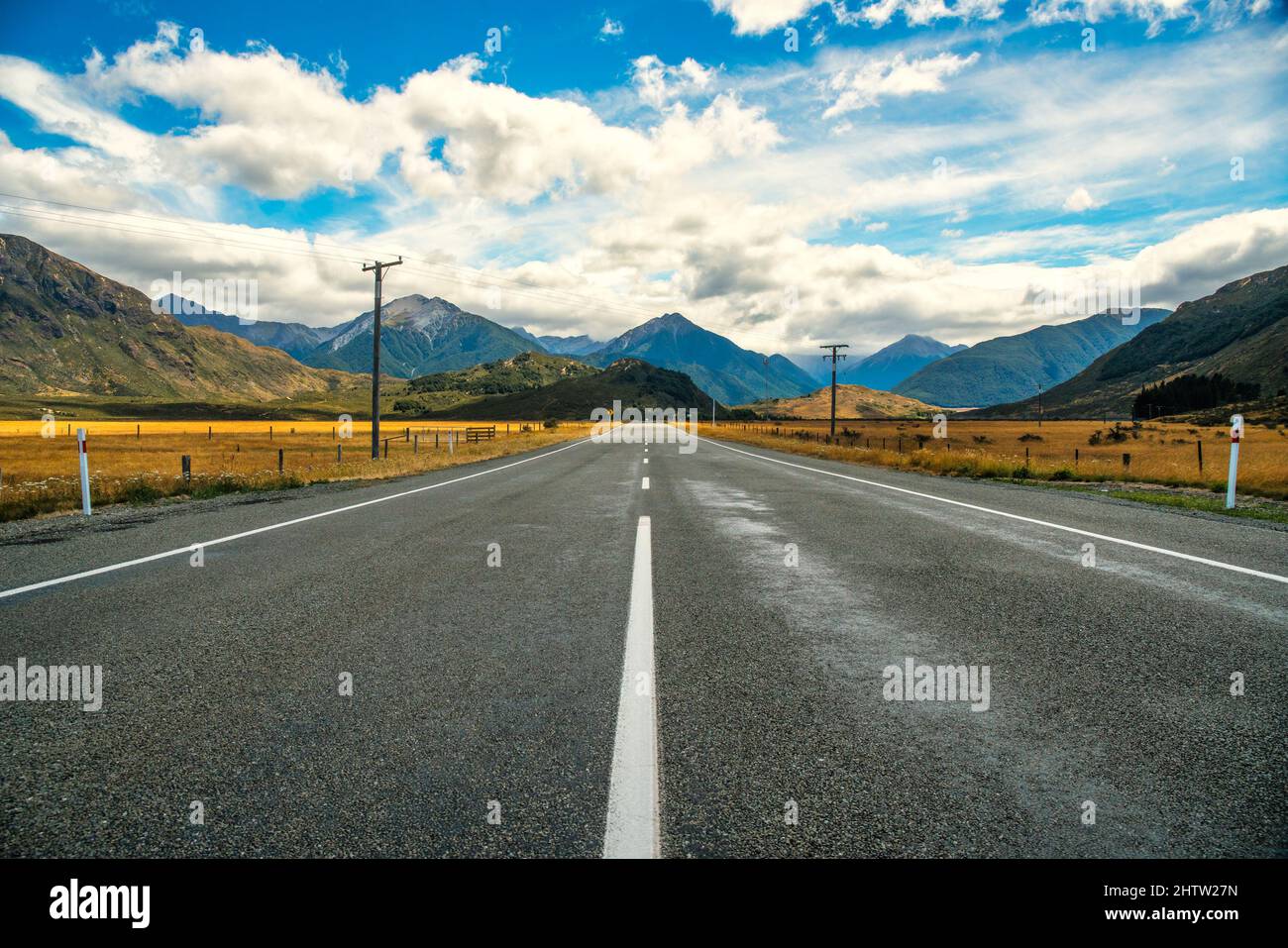 Driving down a long straight to the  mountains on The main State Highway in the Lake Sarah area (near Lake Pearson) NZ Stock Photo