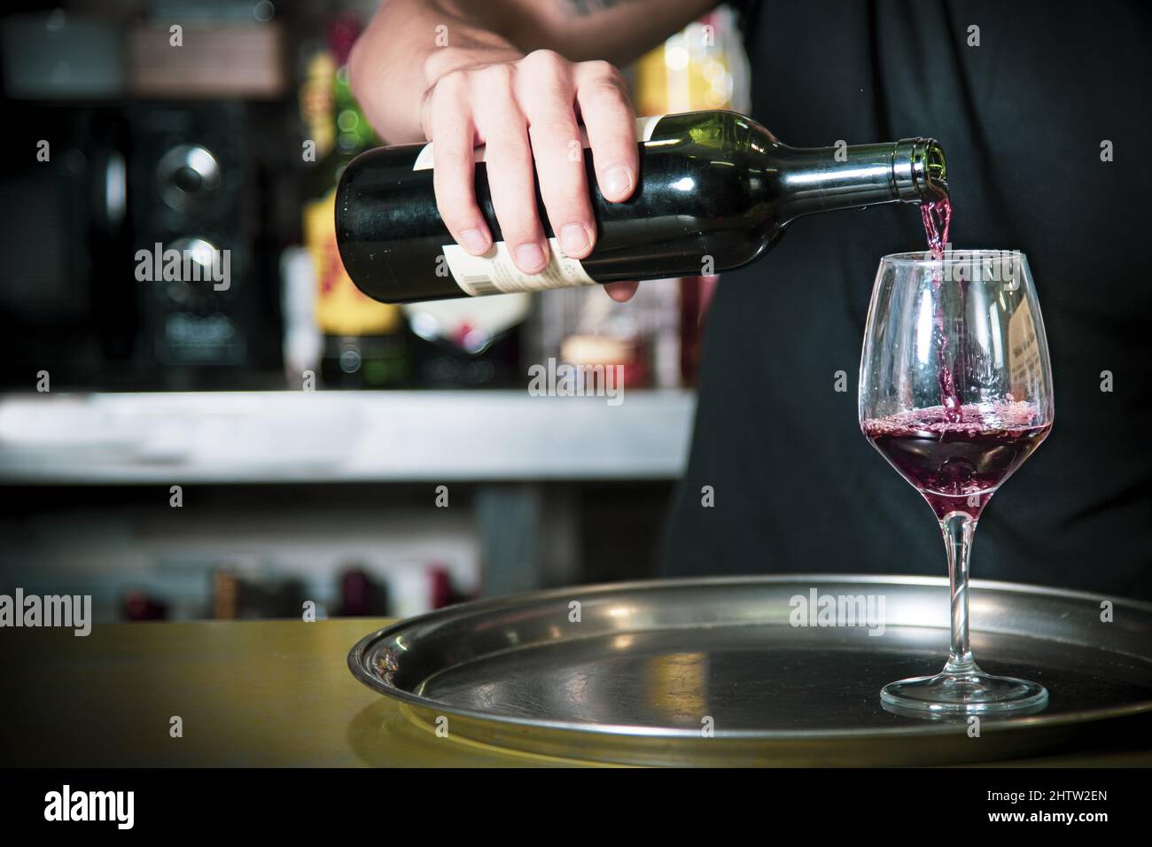 Closeup of a Waiter putting wine in a glass inside the bar Stock Photo ...