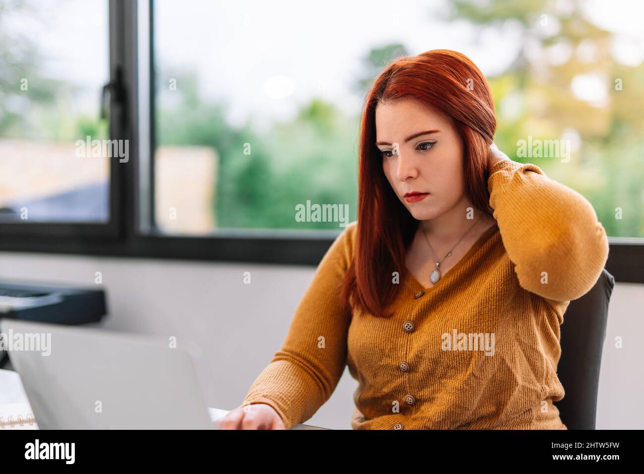 Young woman working on laptop from home Stock Photo