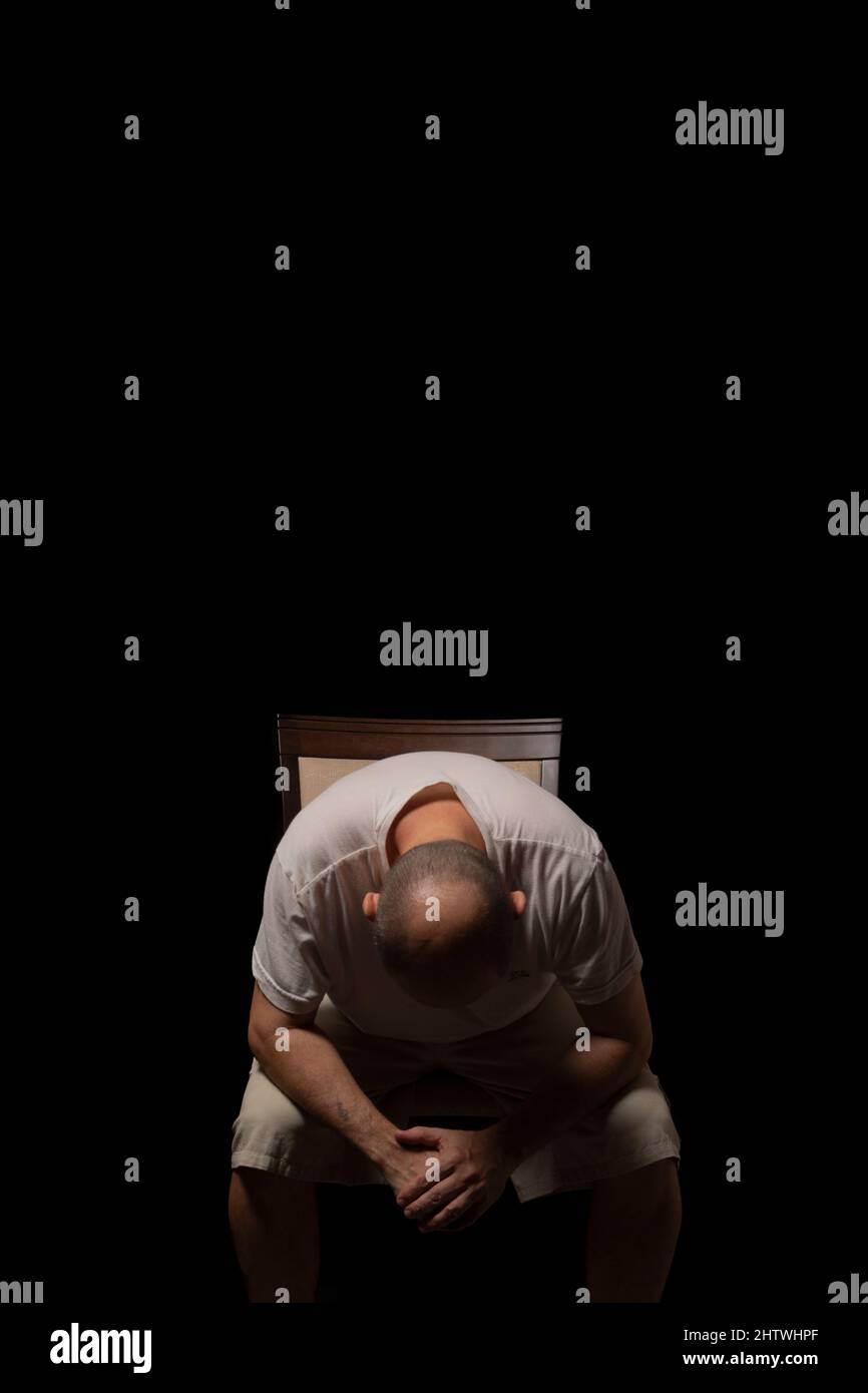 Portrait of a man sitting against a black background. Salvador, Bahia, Brazil. Stock Photo