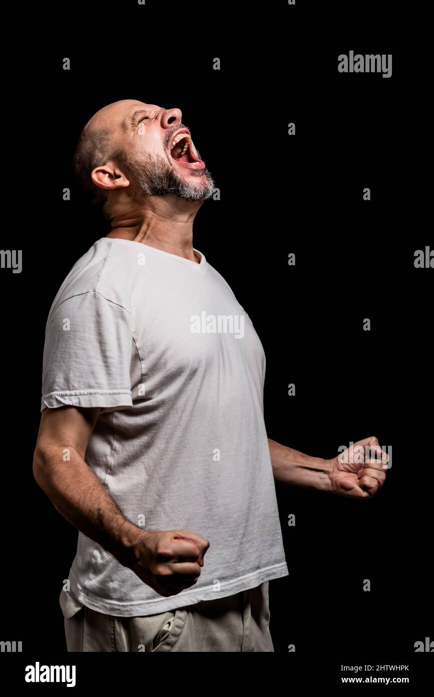 Portrait of a man standing against a black background. Salvador, Bahia, Brazil. Stock Photo