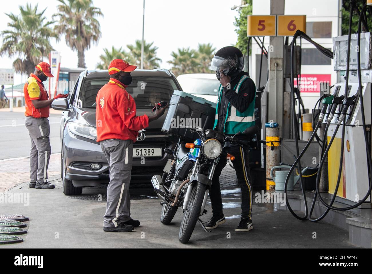 Cape Town, South Africa. 2nd Mar, 2022. A courier pays for fuel at a