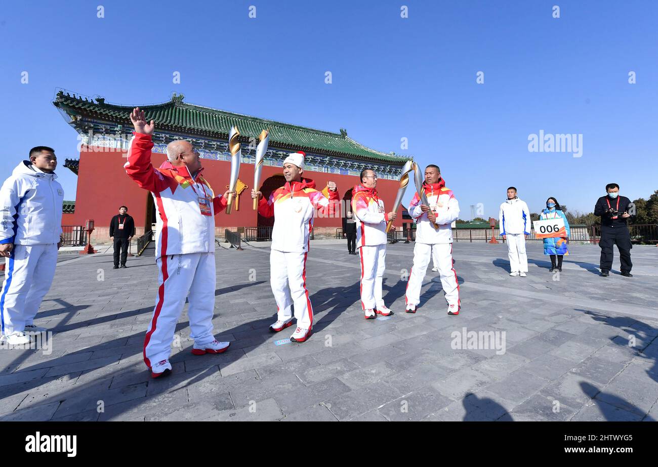(220302) -- BEIJING, March 2, 2022 (Xinhua) -- Torchbearers Ren Baocang, Qi Wensheng, Yang Jianzhong and Daindzin (from L to R) hand off the flame during the Beijing 2022 Paralymic Torch Relay and Flame Lighting Ceremony at the Temple of Heaven park in Beijing, capital of China, March 2, 2022. As the Paralympic Heritage Flame for the Beijing 2022 Winter Paralympic Games was lit on Monday in Stoke Mandeville, a village northwest of London that is recognized as the birthplace of the Paralympic Games, the flame also collected at eight other locations in Beijing and Zhangjiakou gathered at the Tem Stock Photo