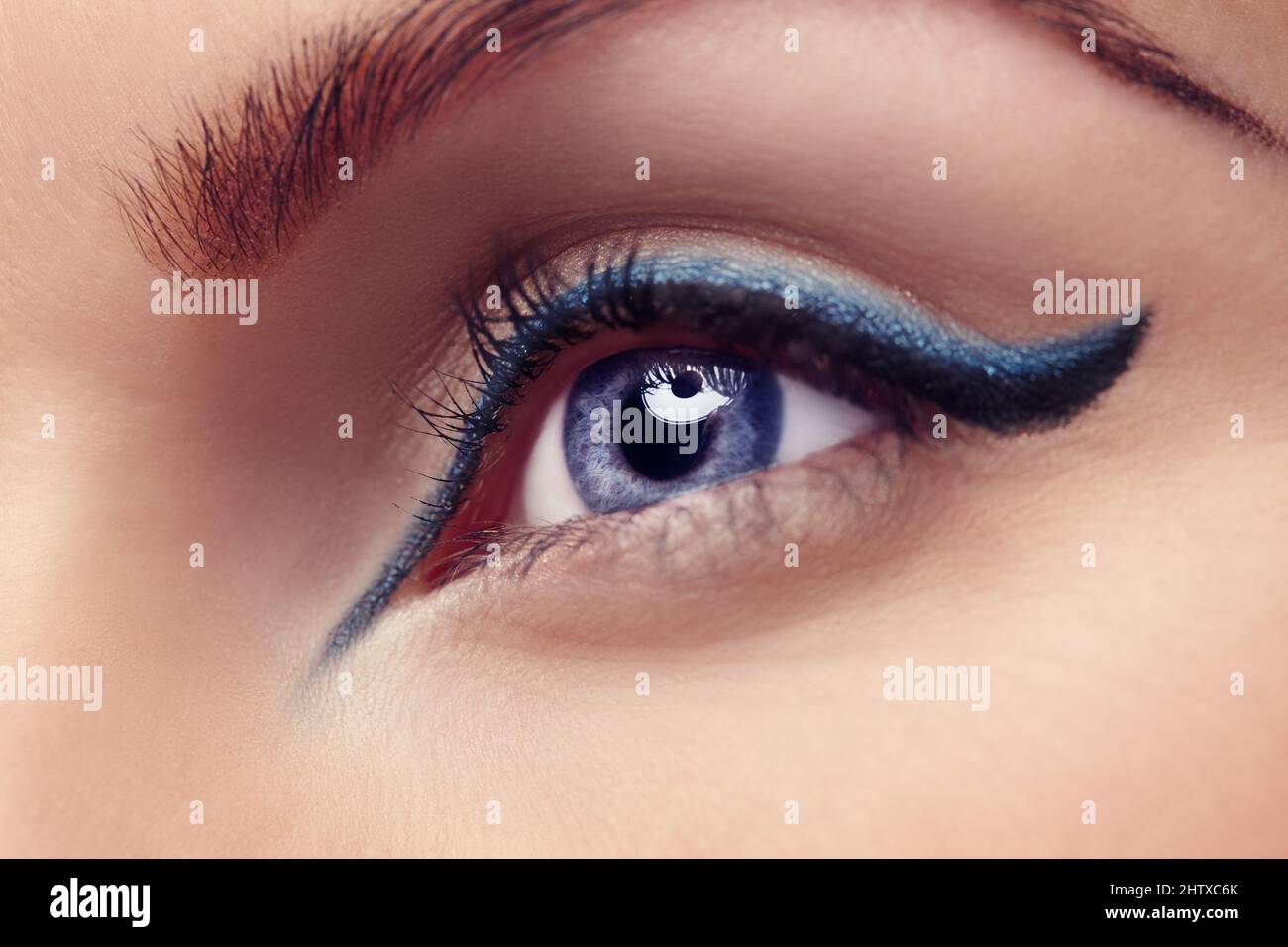 The eyes are the window to the soul. Close up of a blue eye with blue eyeliner. Stock Photo