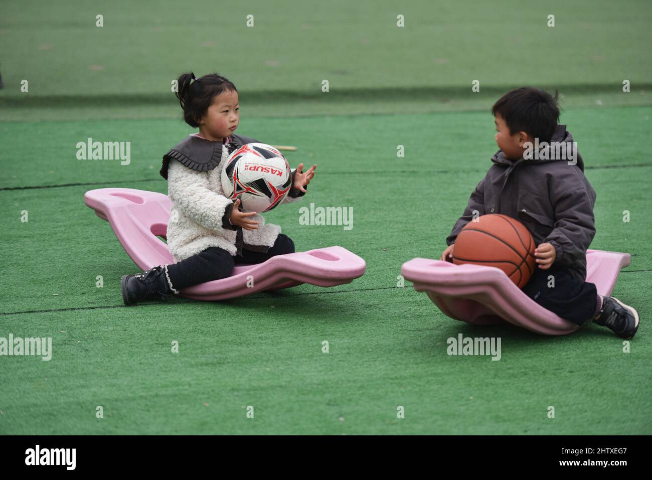 Two children are playing with a ball in the playground of the kindergarten.The National Bureau of Statistics of China released the Statistical Communique on the 2021 National Economic and Social Development. According to the communique, China's population at the end of 2021 was 1,412.6 million, an increase of 480,000 over the previous year, including 914.25 million permanent urban residents. There were 10.62 million births, with a birth rate of 7.52 per thousand. 10.14 million people died, with a mortality rate of 7.18 per thousand. The natural growth rate is 0.34%. (Photo by Sheldon Cooper / Stock Photo
