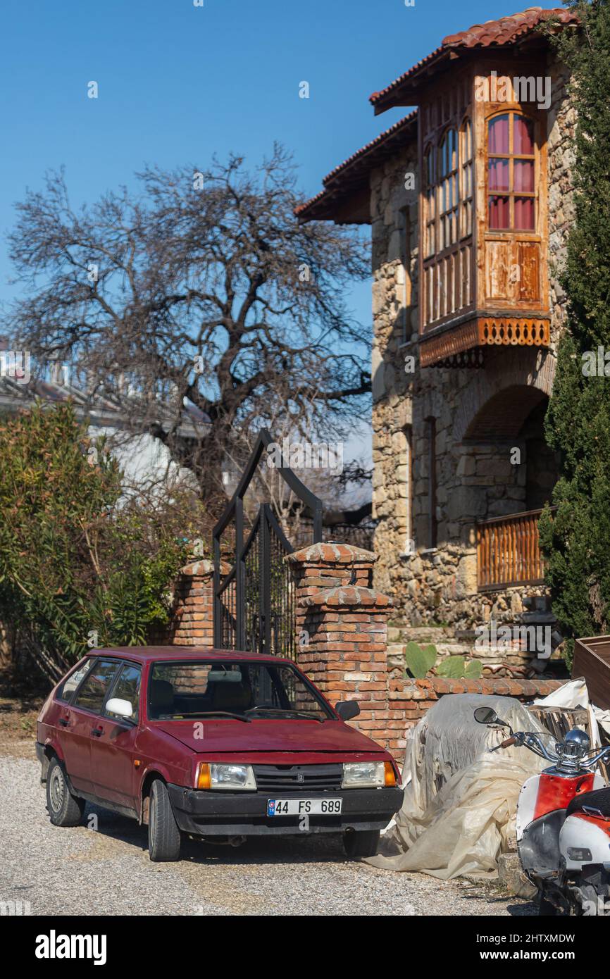 Side, Turkey -February  13, 2022: red VAZ 2109  is parked  on the street on a warm day against the backdrop of a historical centre Stock Photo