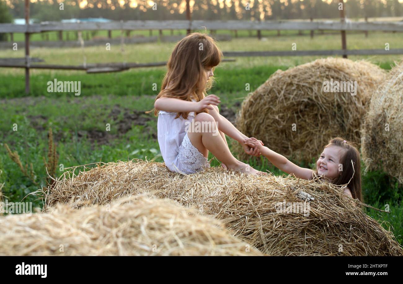 Two little girls playing in a wheat field Stock Photo - Alamy