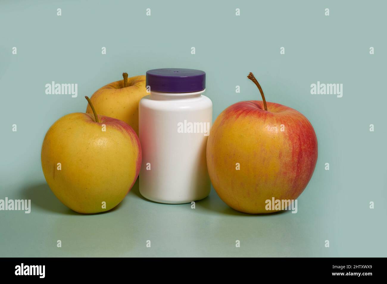 Mock up. A white plastic jar with a purple lid and apples Stock Photo