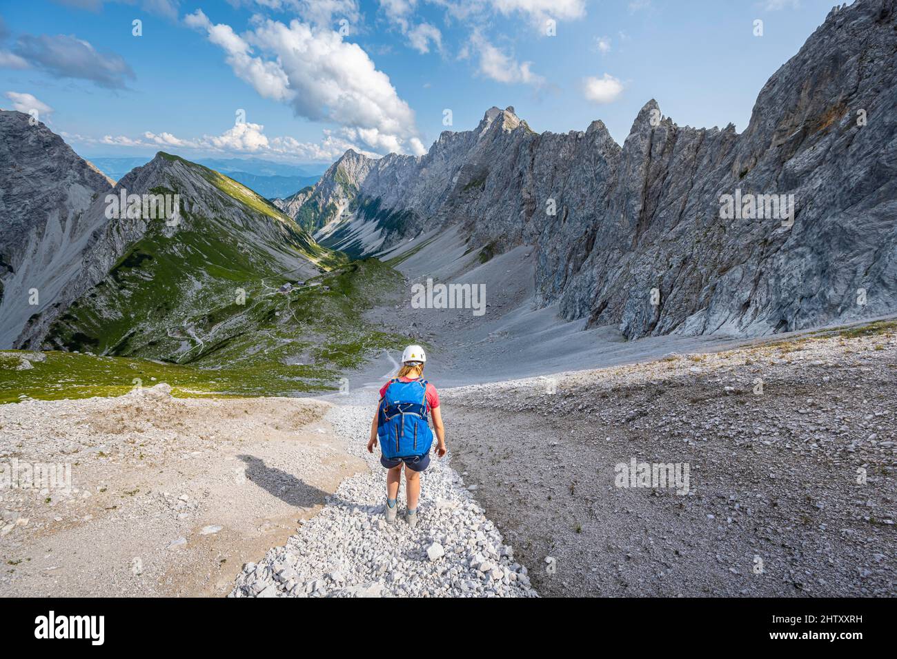 Hiker descends over a boulder field to the Lamsenjochhuette, Karwendel Mountains, Tyrol, Austria Stock Photo