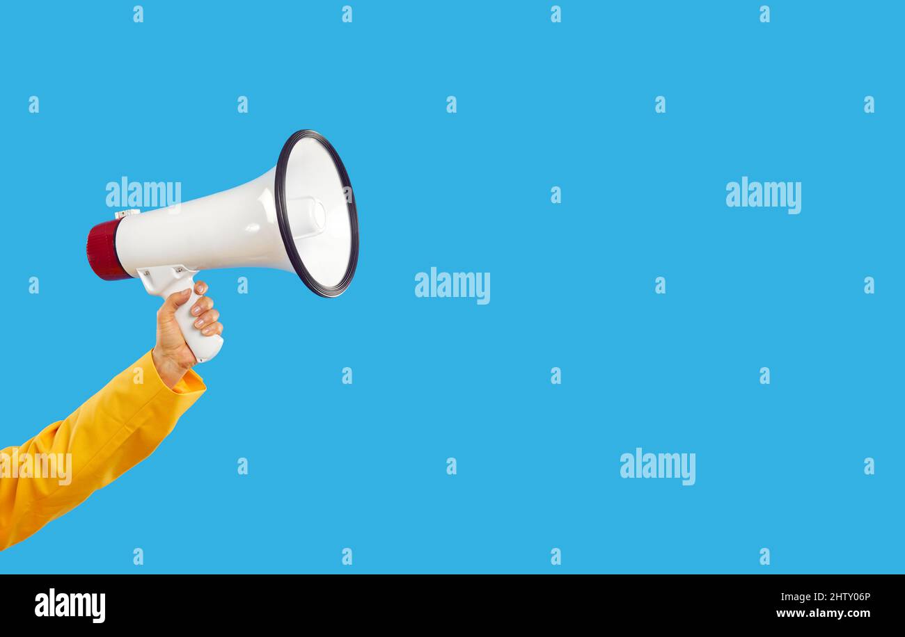 Woman on blank blue copy space background holding megaphone and sharing ...