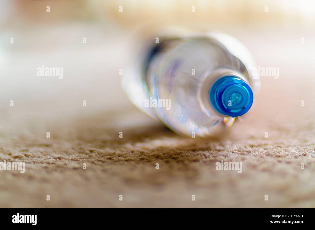 https://c8.alamy.com/comp/2HTY4NH/a-close-up-of-the-lid-or-cap-of-a-plastic-water-bottle-lying-on-a-beige-coloured-carpet-2HTY4NH.jpg